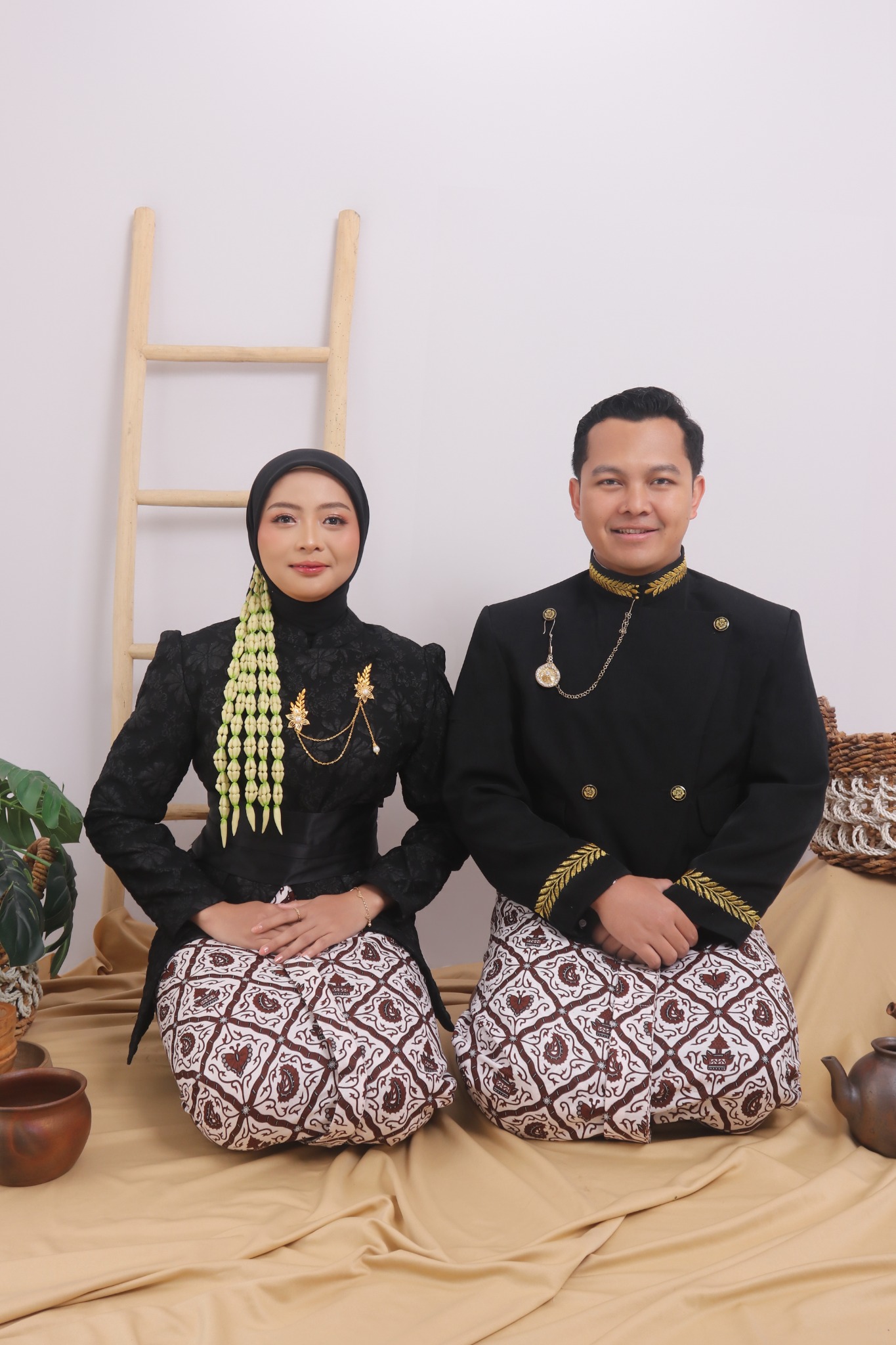 Nila dan Arief duduk bersama mengenakan busana adat Jawa
